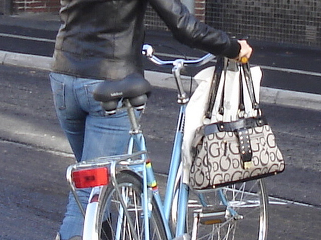 Cycliste en bottes à talons hauts / Walking Swedish biker in jeans & high-heeled boots at her cell phone - Ängelholm  / Suède - Sweden.  23-10-2008