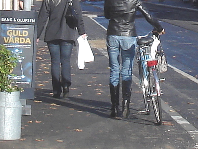 Cycliste en bottes à talons hauts / Walking Swedish biker in jeans & high-heeled boots at her cell phone - Ängelholm  / Suède - Sweden.  23-10-2008