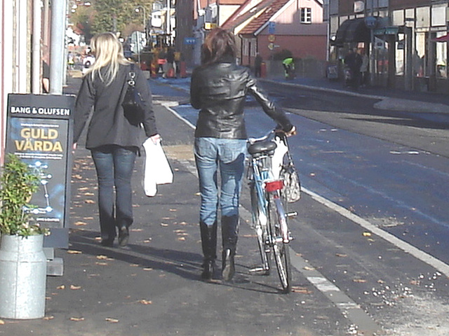 Cycliste en bottes à talons hauts / Walking Swedish biker in jeans & high-heeled boots at her cell phone - Ängelholm  / Suède - Sweden.  23-10-2008