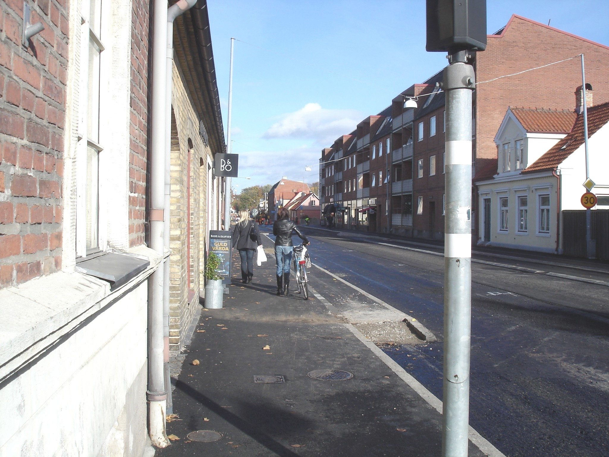 Cycliste en bottes à talons hauts / Walking Swedish biker in jeans & high-heeled boots at her cell phone - Ängelholm  / Suède - Sweden.  23-10-2008