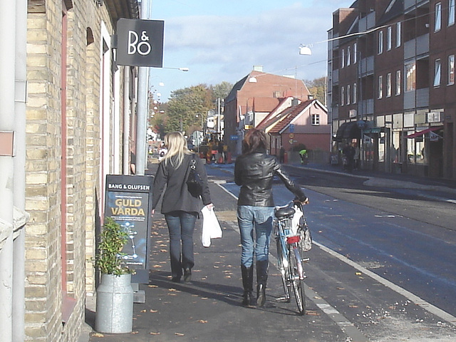 Cycliste en bottes à talons hauts / Walking Swedish biker in jeans & high-heeled boots at her cell phone - Ängelholm  / Suède - Sweden.  23-10-2008