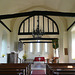 high laver church essex, interior,the outward splay of the chancel arch was arrested in 1963 but still shows despite the strength of the tympanum in the head of the  c15 arch. locke's tomb is just visible on the right wall.