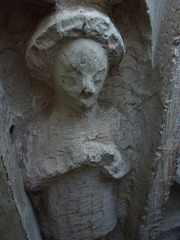little munden church, herts.interestingly unfinished  weeper on chest tomb of sir john thornbury, +1396 and his wife nanarina. this figure is on the west end, and half hidden by the pier; this may indicate that the tomb was finished in the village, otherw