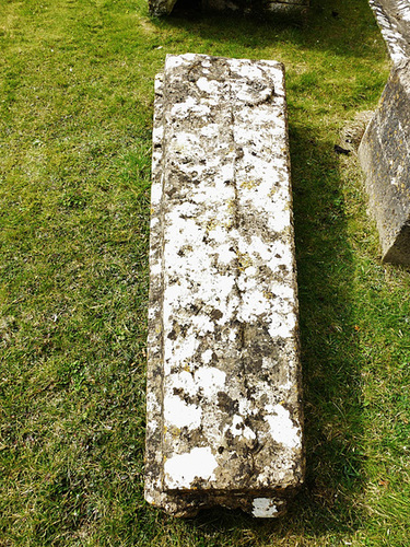 south cerney church , glos.late c12 coffin lid cross slab, with the simple cross in a circle with its long stem raised proud, and ribbons incised spiralling up the stem, perhaps a precursor of the omega style.