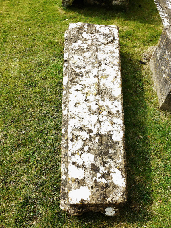 south cerney church , glos.late c12 coffin lid cross slab, with the simple cross in a circle with its long stem raised proud, and ribbons incised spiralling up the stem, perhaps a precursor of the omega style.