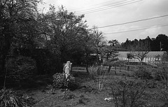 Woman gardening with a wide-rimmed sun hat and long clothing