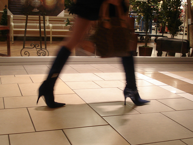 Asian Booty shopping in high-heeled boots / Jeune Dame Asiatique en bottes à talons aiguilles au centre commercial.