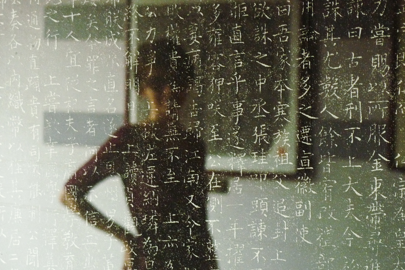 A lovely woman behind/in front of the stone tablet
