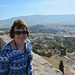 Mary, at the Acropolis wall, with the Temple of Olympian Zeus visible over her left shoulder and the ruins of the Theater of Dionysus Eleuthereus below right.