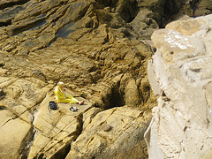 Mujer sobre las rocas de la playa / Virino sur marbordaj rokoj