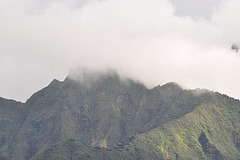 El la turisma bazo videblas impona vulkano, kovrita de nuboj