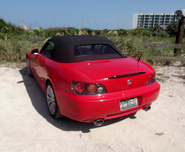 Honda rouge décapotable sur sable / Red convertible Honda on sand.