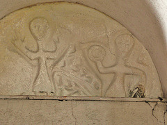 wordwell church, suffolk,early c12 north doorway tympanum, interior. this primative carving , which pevsner thinks pagan, seems to me more likely christian, and to show the raising of the circular host on the right and the figure to the left in adoration