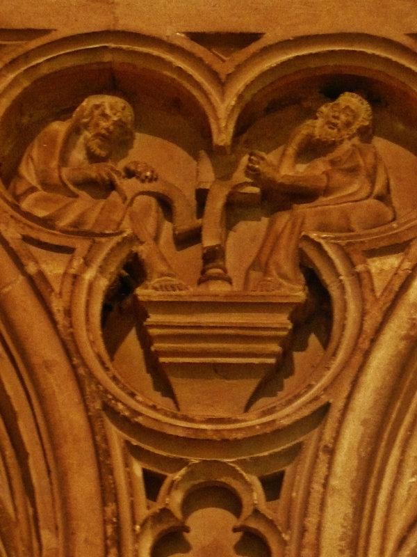 canterbury cathedral,c14,detail of monks at lecterns and disputing fill the spandrels of the canopy on the tomb built for archbishop meopham , who died in 1333 makes a screen across the entrance to the chapel of st.anselm. the canopy is an afterthought, a