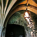 st.bartholomew the great, london,doorway of late c12 in cloister to south of chapter house, probably originally leading to the day stair to the dorter. it has a rounded trefoil arch inscribed onto the segmental tympanum under the round norman head. the  v