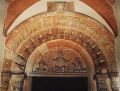 siddington church, glos,south doorway of  the mid c12, with a devil over an archway of especially lively beakhead, one of which has arms grasping its neighbours beaks, and a tympanum showing christ with peter and paul