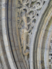 peterborough cathedral,the doorway to peterborough's refectory to the south of the cloister is very ornate, with dragons in the stiffleaf of its tympanum. it dates from the early mid c13.