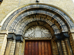 st.james the less church, bethnal green, londonwhen j.antony-lewis rebuilt the bombed front of vulliamy's church, he set it back from the tower and refaced the resultant scar , placing this doorway there as an entrance to the church. the new tympanum