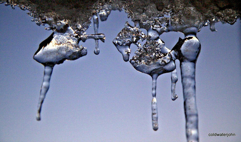 Icicles like melted metal against the sky at dusk...