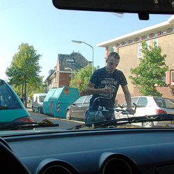 Young man making a call in front of my car Young man making a call in front of my car