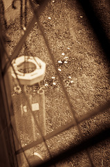 Wind chimes, through glass with daisies.