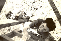 Mom's friend laughs watching her climb the ladder to the guard tower at the foreign national detention camp near New Orleans, 1944.