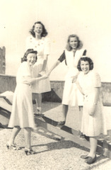 My mom and work friends, c. 1940, New Orleans, cavorting on the roof of their government office building.