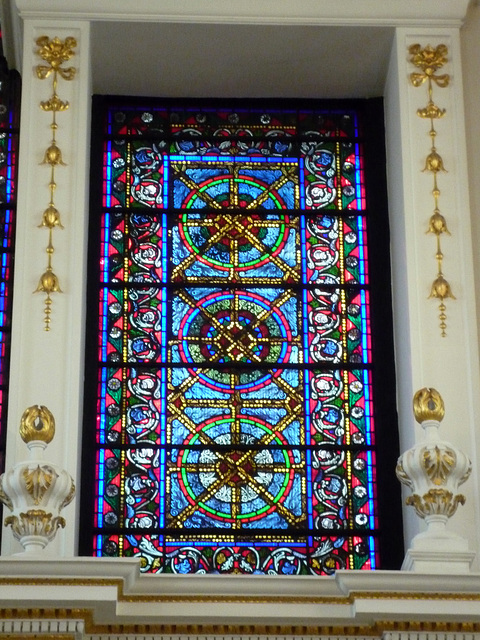 Intricate stained glass window above the altar