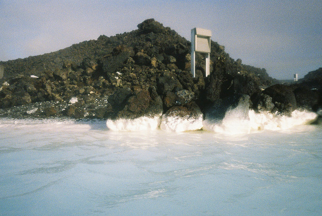 white mineral deposit on black volcanic rock