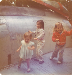 Three little gremlins, cavorting on the wing of a used F-86 Sabre aircraft.