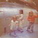 Three little gremlins, cavorting on the wing of a used F-86 Sabre aircraft.
