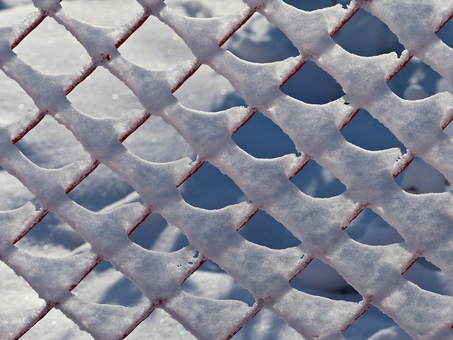 Winter pattern on orange fence