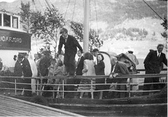 (078) Brudeparet Hilma (Svendsen) og Signold Solem, 16. august 1950. Saudafjord legger til kai ved Sjøtun. Brudgommen (t.v.) og Magnus Kroken (nr. 2, f.h.) følger nøye med. Jens Bergum (på rekka) hopper i land.