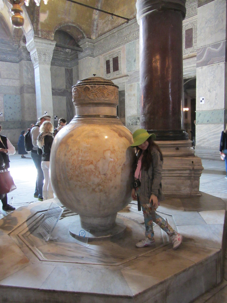 Little tourist strikes a pose for her mom at the giant urn