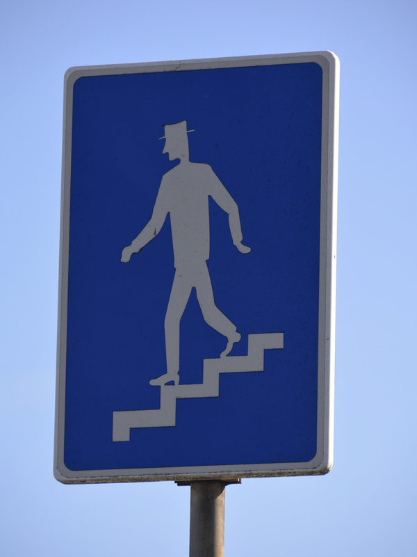 Man with hat walks down the stairs