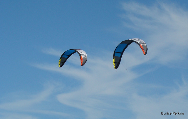 Surfing kites against the sky