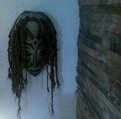 The mask clings to the wall...