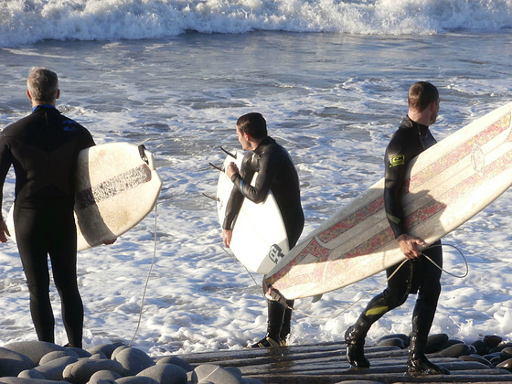 Two surfers coming in and one thinking about going out