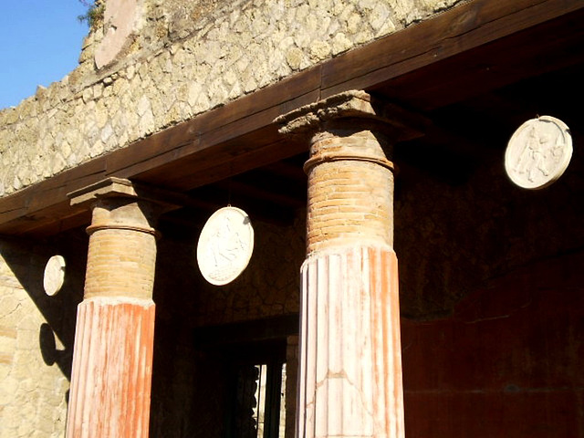 Columns alternating with suspended round bas-reliefs.