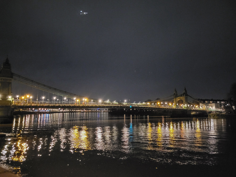 An aeroplane flying over Hammersmith Bridge