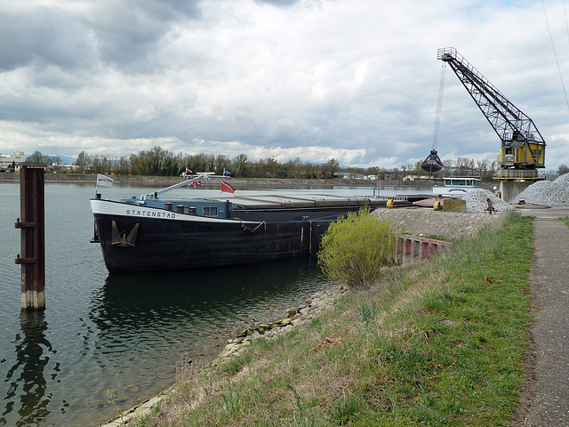 Verladekran der älteren Generation, und eim Motorfrachtschiff, aus eben auch noch dieser Zeit beim Beladen in Breisach