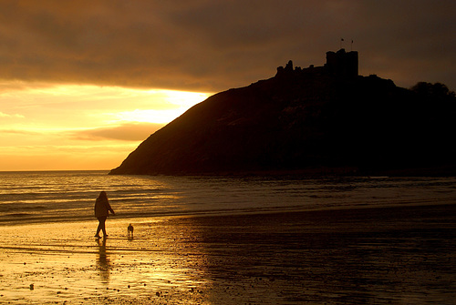 Lady walking the dog on Criccieth beach