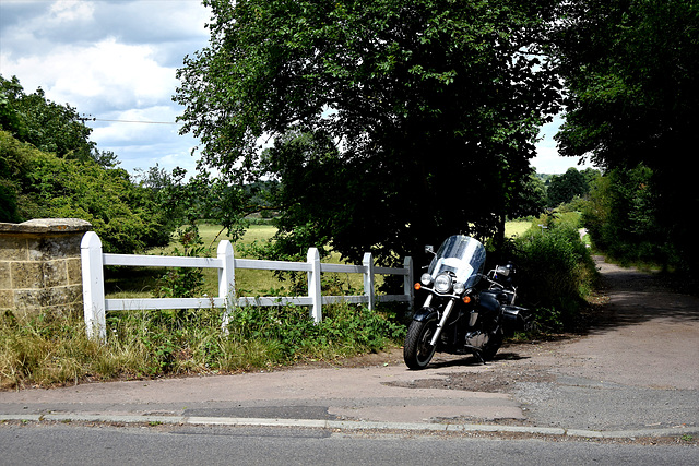 White fence, black motorbike