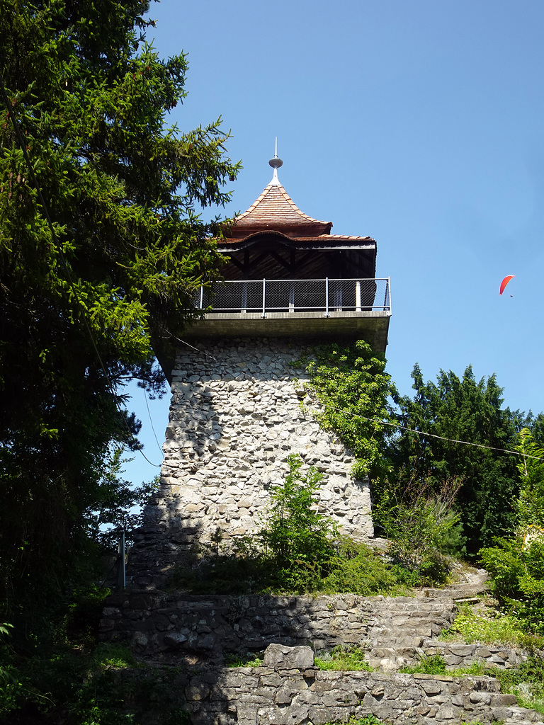 Der Heimwehfluhturm wird von einem Gleitschirm umflogen