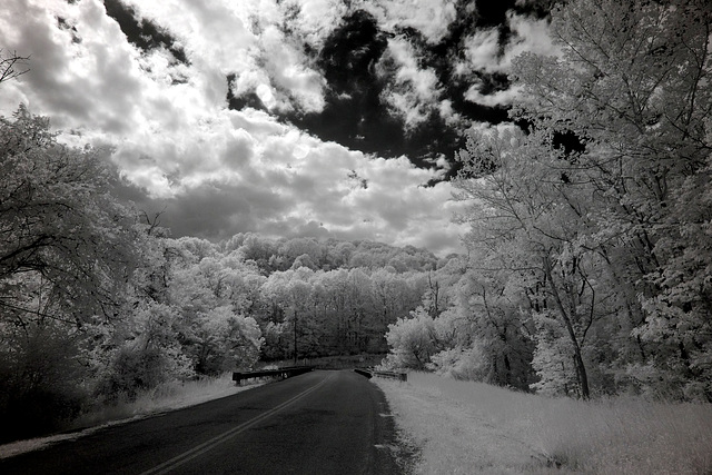 Hills, woods, clouds, and a road to ?