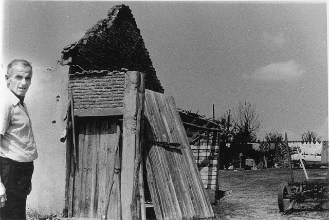 man at house by bombed bridge