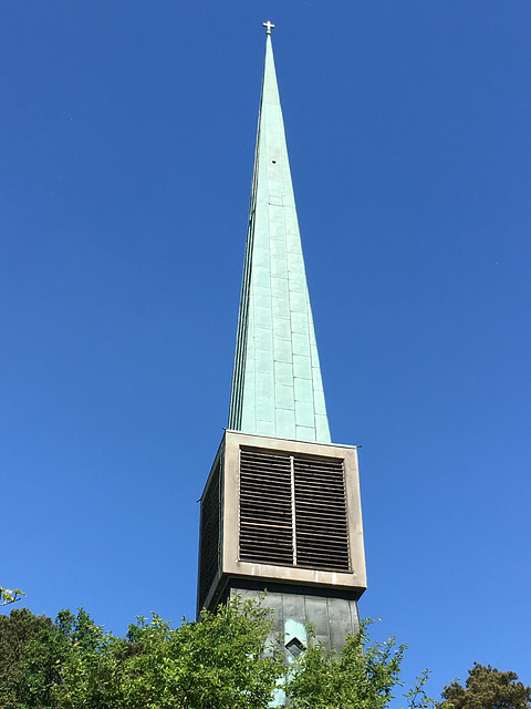Kirchturm am Wiesenweg sticht in Himmel