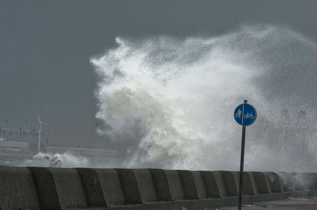 Wave crashing over the promanade wall.