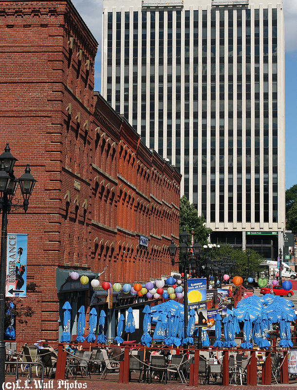 Blue Umbrellas Under Looming Facades