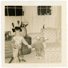 Boy in Halloween Costume with Scarecrow and Jack-O'-Lantern